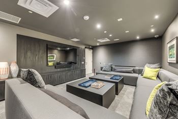 A modern living room with grey couches and a black coffee table.